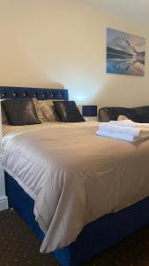 Bv Comfy Studio At Deighton Huddersfield في هدرسفيلد: غرفة نوم مع سرير كبير مع اللوح الأمامي الأزرق