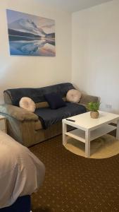 ein Wohnzimmer mit einem Sofa und einem Couchtisch in der Unterkunft Bv Comfy Studio At Deighton Huddersfield in Huddersfield