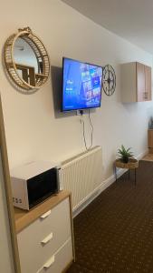 a living room with a flat screen tv on a wall at Bv Comfy Studio At Deighton Huddersfield in Huddersfield