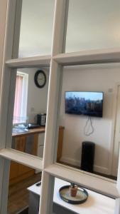 a view of a living room with a tv in a mirror at Bv Cosy Studio Eleven At Deighton Huddersfield in Huddersfield