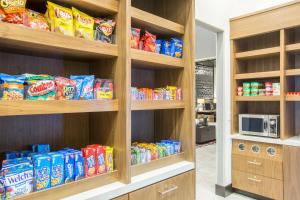 a pantry with wooden shelves filled with chips and snacks at Holiday Inn Portland West - Hillsboro, an IHG hotel in Hillsboro