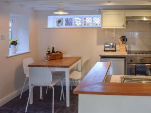 eine Küche mit einem Holztisch und Stühlen in der Unterkunft Rowan Cottage in Aislaby