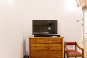 una TV seduta sopra un comò in legno di La Dimora del Principe a Bagnoregio