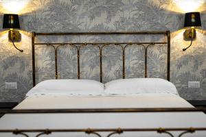 una camera da letto con un letto con due luci sul muro di La Dimora del Principe a Bagnoregio