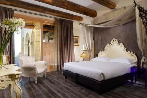 a bedroom with a king sized bed and two chairs at Tenuta Le Cave in Tregnago