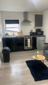 a living room with a kitchen with a table and a couch at BV Royal Comfy Studio Seven Suite Queensgate Huddersfield in Huddersfield