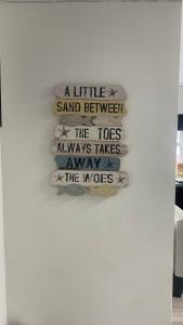 a sign on a wall that reads a little sand between the toes always takesaway at BV Royal Comfy Studio Seven Suite Queensgate Huddersfield in Huddersfield