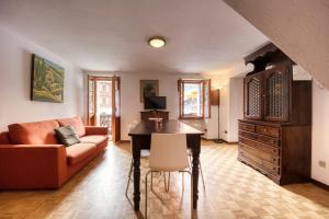 - un salon avec un canapé et une table dans l'établissement Incanto Walser Apartments Piazza, à Macugnaga