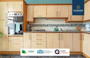 a kitchen with wooden cabinets with a sign in front of it at DUPLEX - 5 Bed Rooms, Amazing Views, Fully Equipped, Free Parking, WiFi, FAVOURITE for Groups & Businesses, Food, Bars, Shops, Library, River Views, by SUNRISE LONG LETS and SERVICED ACCOMMODATION DUNDEE in Dundee +68 photos