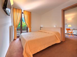 een hotelkamer met een bed en een balkon bij Hotel Alaska in Folgarida