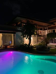 a swimming pool at night with a house at Kiss Bali Villas in Seminyak