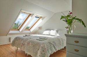 a bedroom with a bed with a dresser and two windows at Red Haven Cottage in Edsbruk