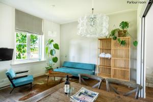 a living room with a blue couch and a table at Boutique hotel Villa Oldenhoff in Abcoude