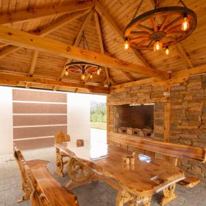 a dining room with a wooden table and a fireplace at Vila Oaza mira Draganići in Raška