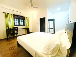 1 dormitorio con 1 cama, 1 silla y 1 ventana en The Ivy Lake en Anuradhapura