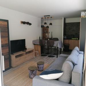 uma sala de estar com um sofá e uma mesa em Appartement en résidence bord de mer em Kerhermain