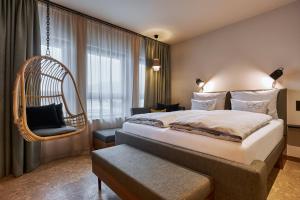 ein Hotelzimmer mit einem Bett und einem Stuhl in der Unterkunft Cocoon Salzburg in Salzburg
