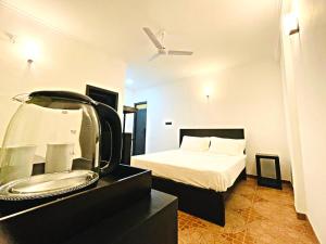 ein Schlafzimmer mit einem Bett und ein Badezimmer mit einem Waschbecken in der Unterkunft The Ivy Lake in Anuradhapura