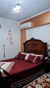 - une chambre avec un grand lit et une couette rouge dans l'établissement Star House City Stars, au Caire