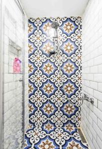 y baño con ducha de azulejos azules y blancos. en Elele Boutique Aparts en Estambul