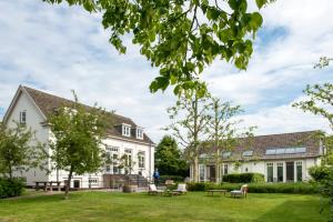 ein großes weißes Haus mit einem Hof in der Unterkunft Boutique hotel Villa Oldenhoff in Abcoude