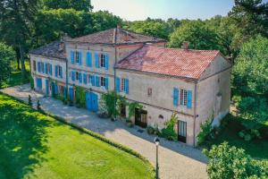 an aerial view of a large house with blue doors at Le Manoir du Thouron in Saint-Sulpice