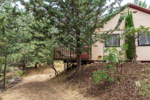 a house with a wooden deck in the woods at Historical Cabin in Julian Pet's okay! in Julian