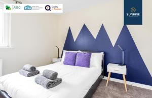 a bedroom with a large bed with towels on it at THE TOWNHOUSE, 4 Rooms Large Beds, Poker Table, Fully Equipped, Easy Ring-Road Access, Parking, WiFi, FAVOURITE for Contractors & Groups, Long Stay Rates Available by SUNRISE SHORT LETS in Dundee