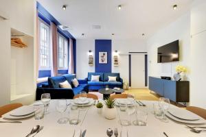 a living room with a table and a blue couch at CMG Marais/ Republique F in Paris