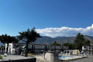 a building with a pool and mountains in the background at Super 8 by Wyndham Penticton in Penticton