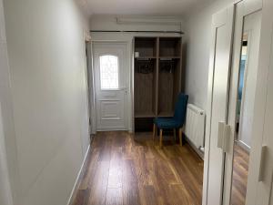 un couloir avec une chaise bleue et un placard dans l'établissement Hollybush Guest House, à Oxford