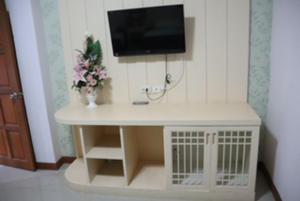 a small white table with a tv on a wall at Tokyo Country Inn in Nakhon Ratchasima