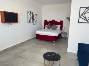 a bedroom with a bed and a tv and a table at 15 On Burns Guesthouse in Cape Town