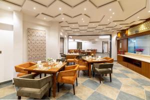 a dining room with wooden tables and chairs at Traavista Aravali Mahal in Udaipur