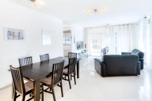 a dining room with a table and chairs and a couch at Luxury Sea Side 3BR by Airsuite in Ashdod