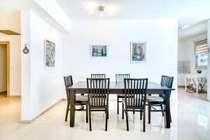 a dining room with a black table and chairs at Luxury Sea Side 3BR by Airsuite in Ashdod