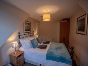 a bedroom with a large bed with blue pillows at Forth Reflections in Queensferry