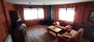 Casa Rural La Torreta en El Rincón de Ademuz في Castielfabib: غرفة معيشة مع أريكة وتلفزيون