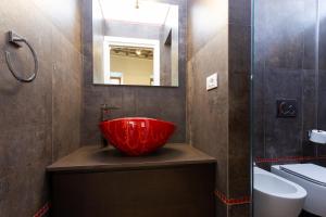 ペルージャにあるAppia Apartment - Relax & Spa - Centro Storicoのバスルーム(赤いボウルシンク、鏡付)