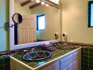 a bathroom with two sinks and a large mirror at Tranquility Beach Suites in Placencia Village