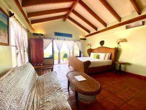 a bedroom with a bed and a couch and a table at Tranquility Beach Suites in Placencia Village