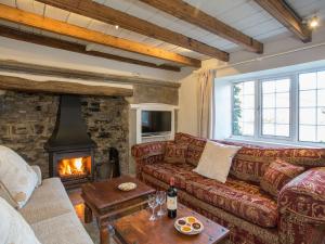 Lyndhurst Cottage في كارلتون: غرفة معيشة مع أريكة ومدفأة