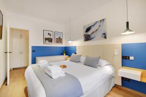 a bedroom with a large white bed with blue walls at CMG Marais // République G in Paris