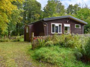 a small house in a yard with a fence at Satchwell - Uk31538 in Kirkhill