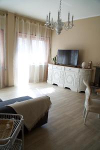 a living room with a television on a white dresser at La Première di Maison Home in Lido di Ostia