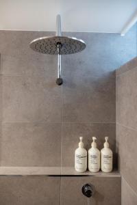 vier witte flessen op een plank in een douche bij Barossa Weintal Hotel in Tanunda