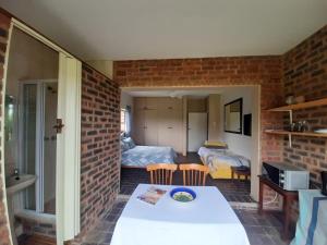 una habitación con una pared de ladrillo y una habitación con una mesa en Secret Sithela, en Port Edward