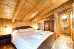 um quarto com uma cama num chalé de madeira em Incanto Walser Apartments Ronco em Macugnaga