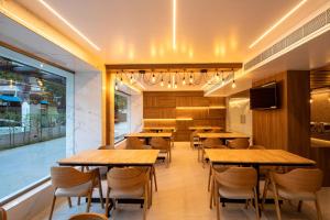 a dining room with wooden tables and chairs at RATHNA RESIDENCY - Near US CONSULATE in Chennai