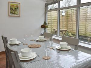 - une table à manger avec des chaises et une table avec des verres à vin dans l'établissement Toms Cottage, à Melmerby